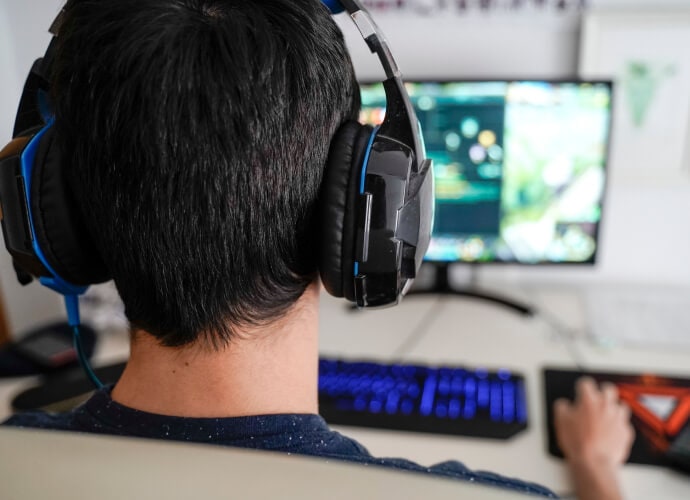 Hombre con auriculares sentado delante de un ordenador