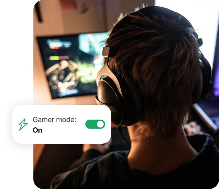 Chico que juega en su equipo y utiliza Norton 360 for Gamers